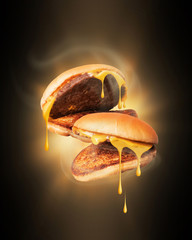 Wall Mural - Two warmed cheeseburger with hot steam in the dark