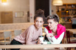 © alfa27 - Two girl friends having a great time in cafe after shopping trip. Friends smiling and sitting in a coffee shop, drinking coffee and enjoying togetherness and company.