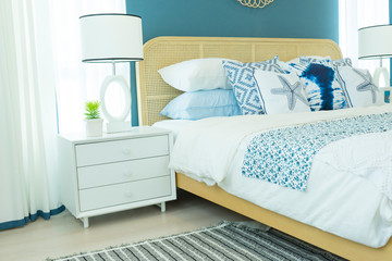 Vintage master bedroom with blue wall and white table lamp.