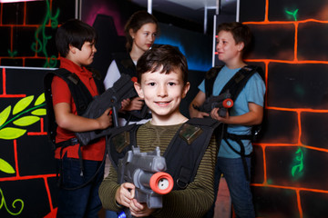 Wall Mural - teen boy standing with laser pistol in dark lasertag room