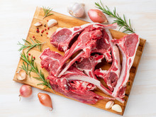 Raw Lamb Ribs On Wooden Chopping Board On White Background, Top View