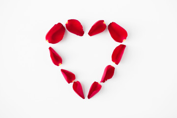 valentines day and romantic concept - heart shape made of red rose petals on white background