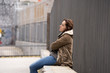 © SB Arts Media - Depressed young woman sitting on urban city street overwhelmed a