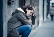 © SB Arts Media - Depressed woman sitting on urban city street overwhelmed and hop