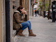 © SB Arts Media - Depressed woman sitting on urban city street overwhelmed and hop