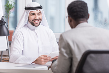 Canvas Print - Arabian businessman smiling and holding digital tablet in office