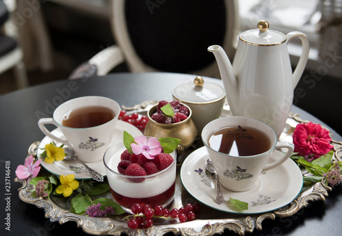 Fotografie, Obraz Tea in old porcelain cups, panakota dessert and raspberry on an old silver tray