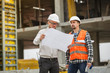 © Volodymyr Herasymov - Male architect and developer discussing blueprints at construction site