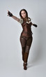 © faestock - full length portrait of brunette  girl wearing brown leather steampunk outfit. standing pose on grey studio background.
