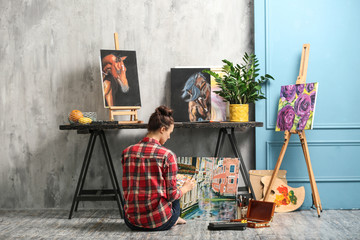 Wall Mural - Female artist painting picture in workshop