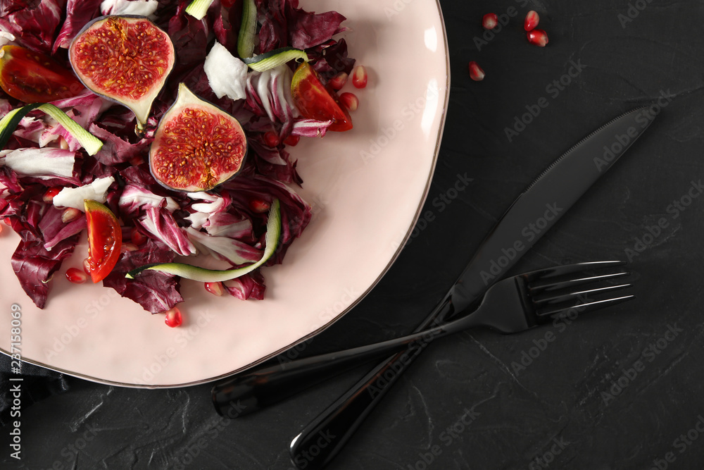 Plate with fresh vegetable salad on dark table