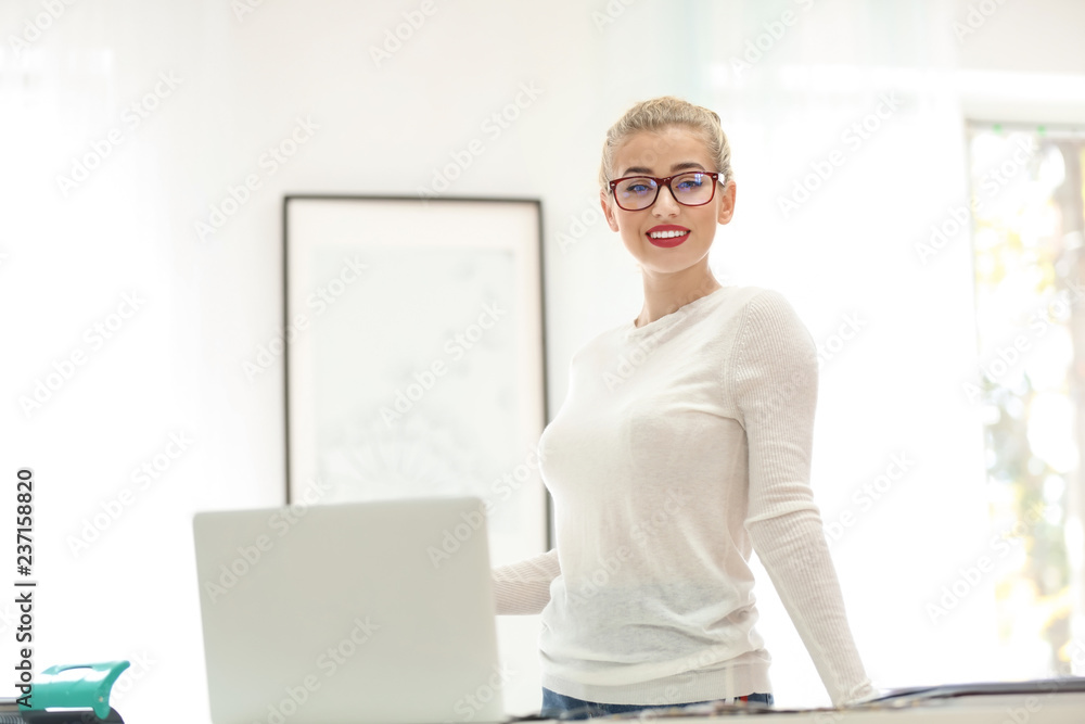 Beautiful young designer working in office
