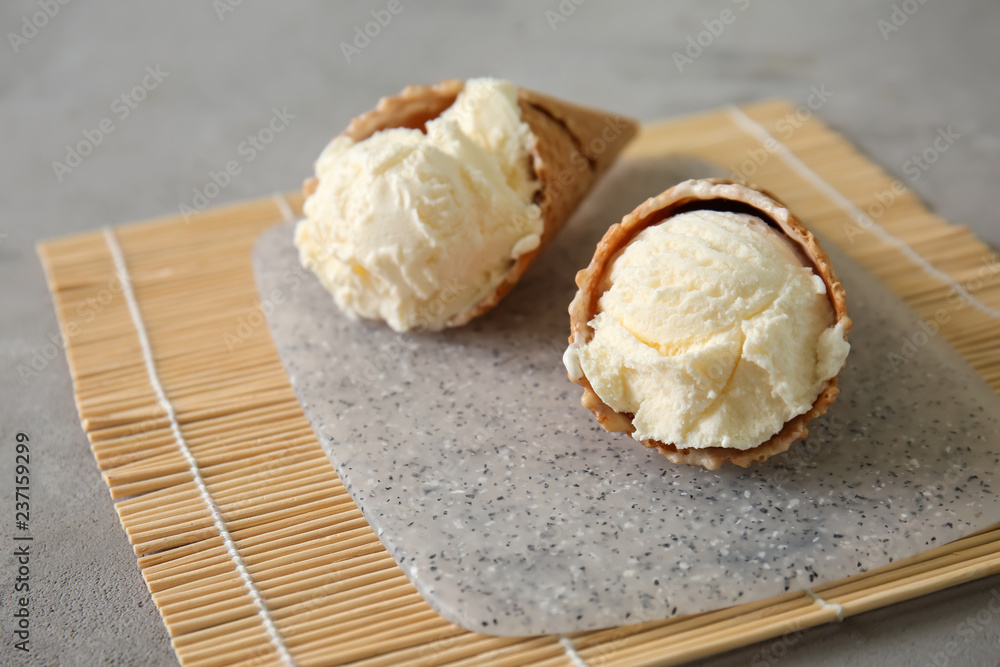 Waffle cones with delicious ice cream on bamboo mat
