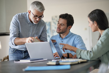 young colleagues with older boss working with computers