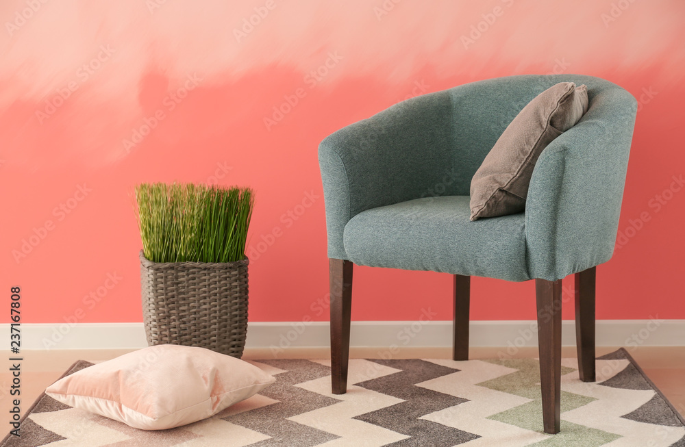Comfortable armchair near pink wall