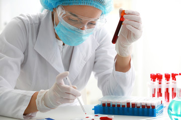 Woman working with blood sample in laboratory