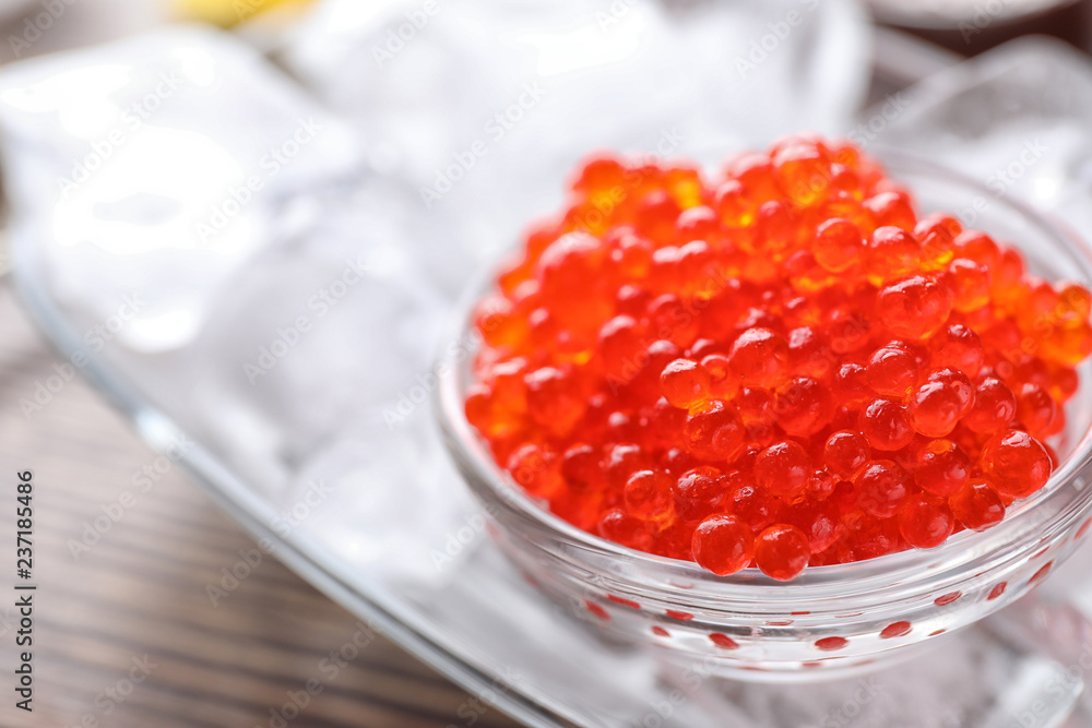 Bowl with delicious red caviar on table, closeup