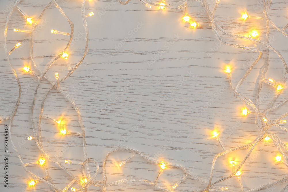 Glowing Christmas lights on wooden table