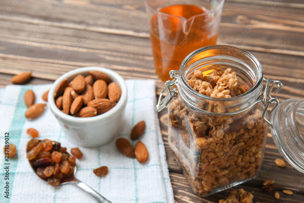 Jar with granola and nuts on wooden table
