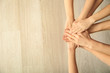 © Pixel-Shot - Young people putting hands together, top view. Concept of unity