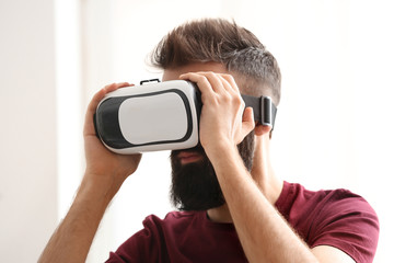 Wall Mural - Man wearing virtual reality glasses at home