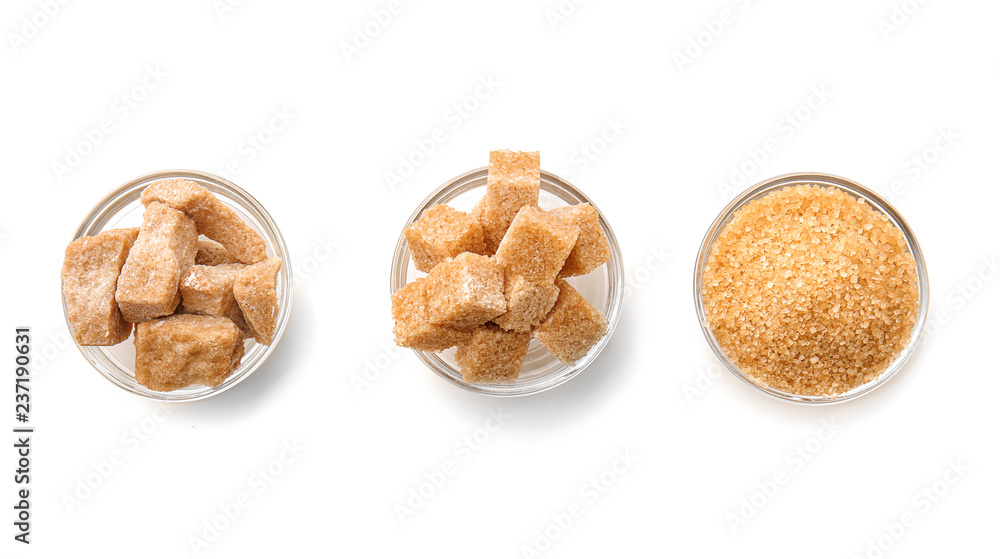 Bowls with different kinds of sugar on white background