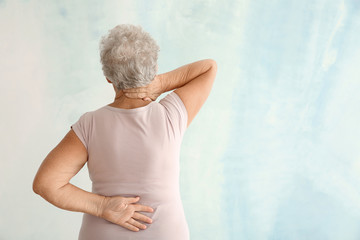 Sticker - Senior woman suffering from back pain on light background