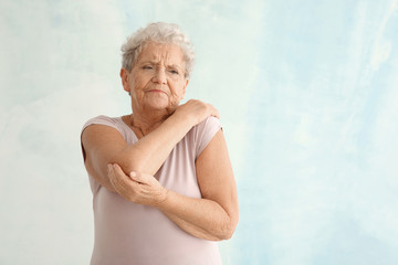 Sticker - Senior woman suffering from pain in elbow on light background