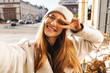 © Drobot Dean - Cheerful young woman dressed in autumn coat and hat