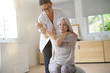Senior woman exercising with her physiotherapist and swiss ball