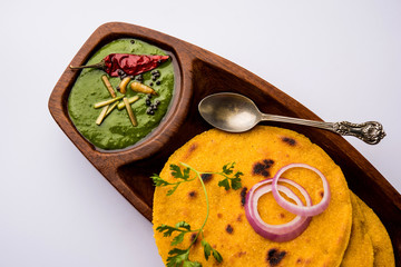 Makki di roti with sarson ka saag, popular punjabi main course recipe in winters made using corn breads mustard leaves curry. served over moody background. selective focus