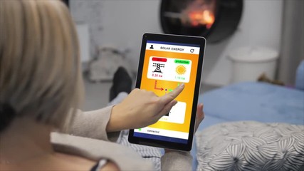 smart home woman monitoring energy consumption and production on tablet app 4k