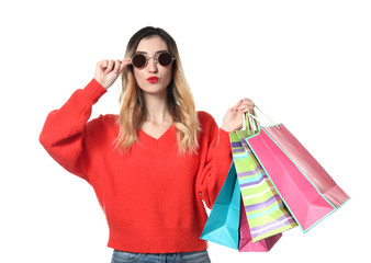 Beautiful young woman with shopping bags on white background