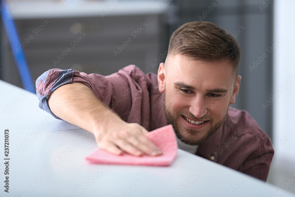 Young man cleaning his flat