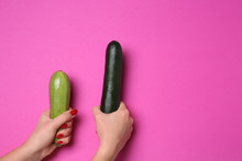 Woman Holding Two Zucchinis On Color Background. Erotic Concept