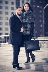 Happy young fashion couple walking on city street