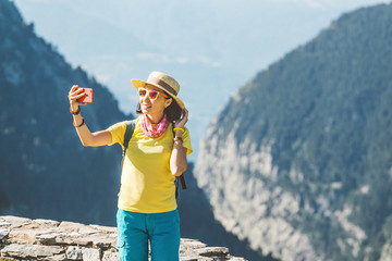 Wall Mural - Smiling young woman takes a selfie in Pyrenees Mountains