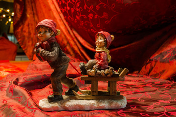 Sleigh ride at Christmas time. 2 figures made of ceramic on a red - gold cloth for christmas decoration )