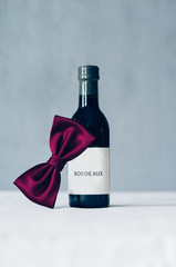 Wall Mural - Bottle of red wine decorated with red bow tie 