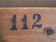 Number 112 on wooden surface