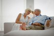 © Erickson Stock - Happy couple looking at each other lovingly while sitting on a couch in their living room.