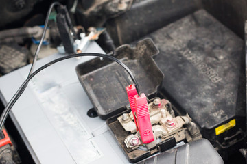 charging a car battery installed at the engine box