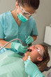 © RG&B Images/Stocksy - Portrait of female orthodontist treating patient in dental office