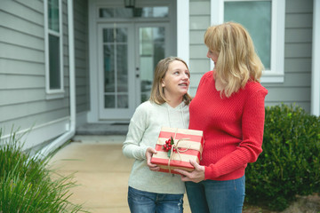 Mother and Daughter Outside their House with a Christmas Gift