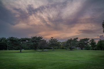 Wall Mural - Dramatic sunset skies over a park