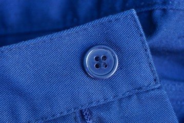 Wall Mural - blue plastic button on the fabric of the jacket sleeve