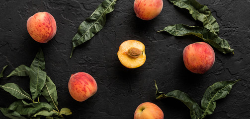 Wall Mural - Ripe peaches on black stone background. Healthy food concept, top view, pattern