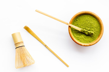 Wall Mural - Matcha powder in bowl near specail stick and whisk on white background top view