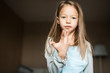 © Ira Efremova Photography/Stocksy - Cheeky little girl practicing gymnastics in her living room.