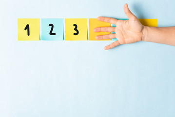 Banner counting 1-2-3. Collection of different colored sticky note papers with curled corner, open palm hand hidden three notes and empty three notes.